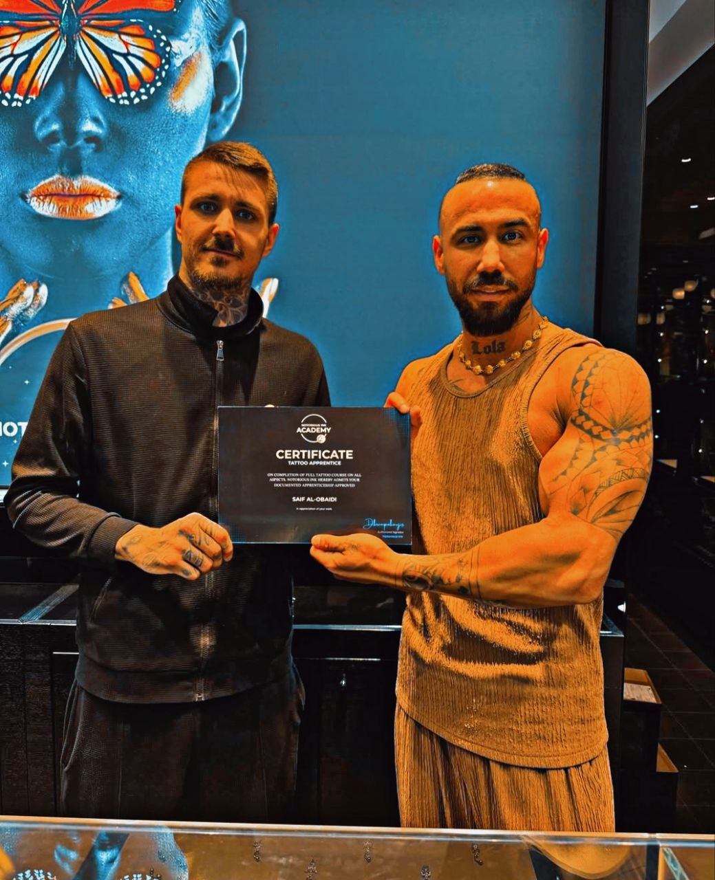 professional male tattoo artist with sleeve tattoos in a black t-shirt, confident pose in studio