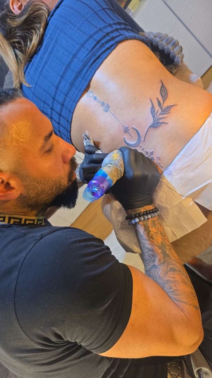 tattoo artist working on client